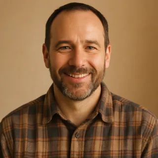 A man with a short beard in a plaid work shirt.