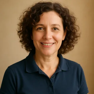 A woman with curly hair in a navy polo shirt.